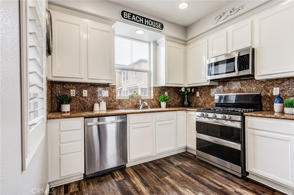 a kitchen with stainless steel appliances granite countertop a stove a sink and a microwave