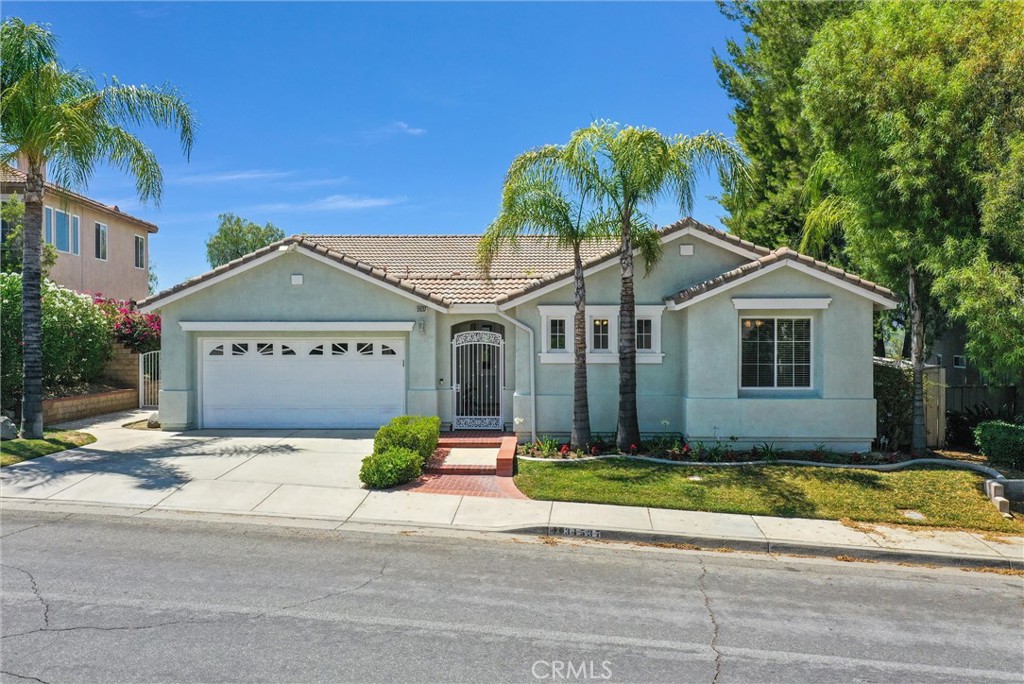 a front view of a house with a yard and potted plants