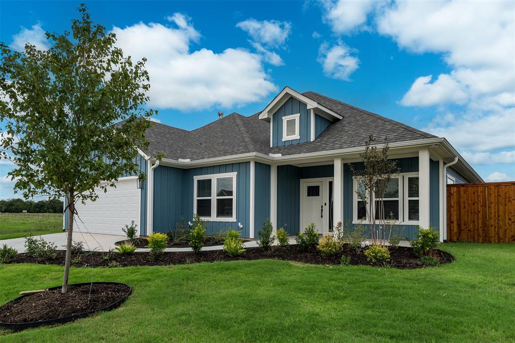 a front view of a house with a garden and yard