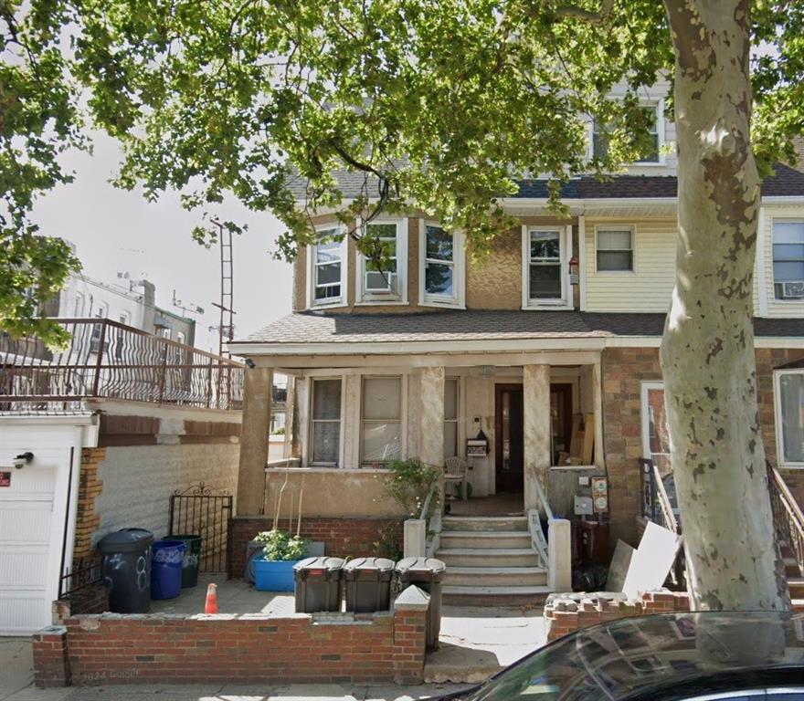 a front view of a house with plants and trees