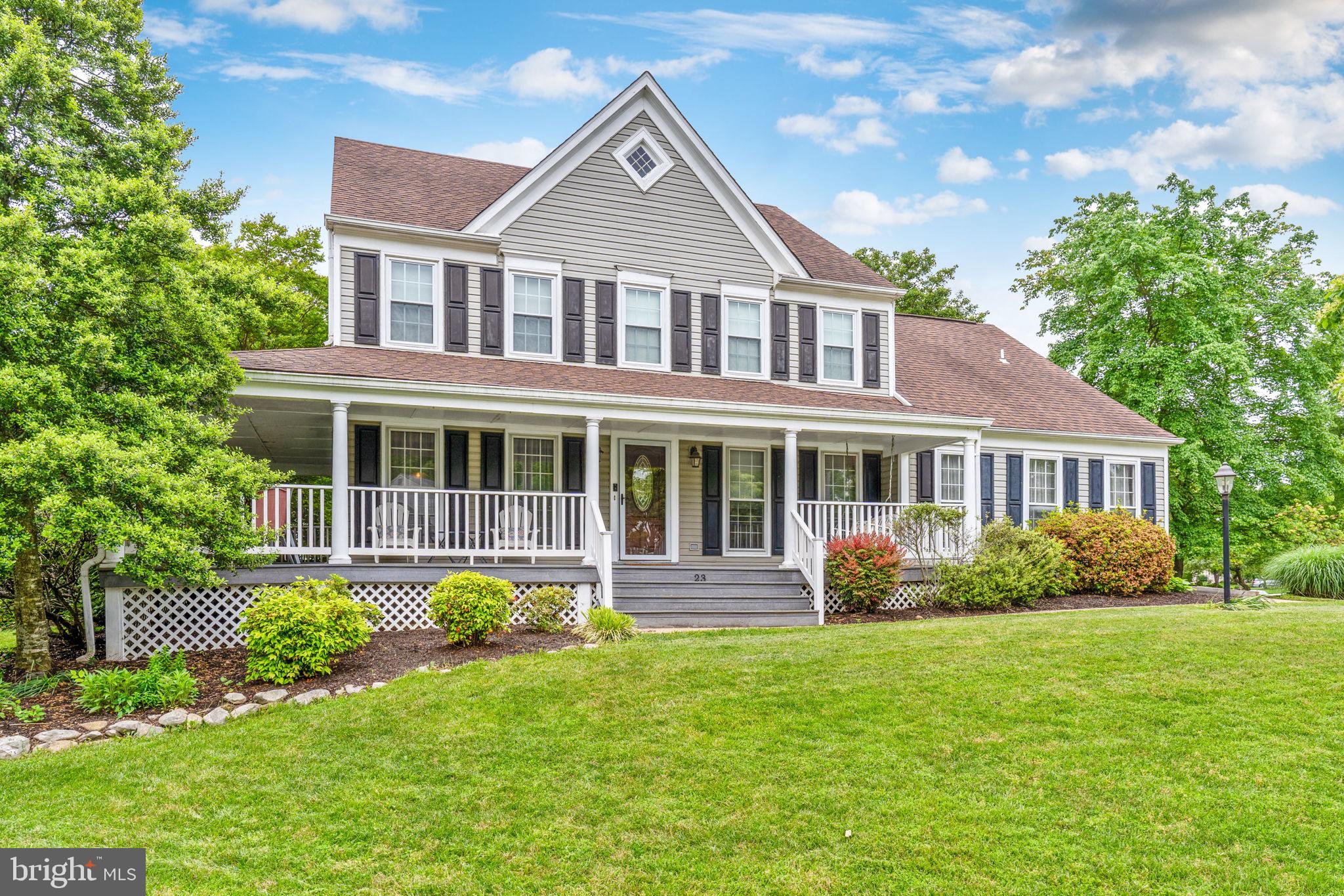 a front view of a house with a yard and potted plants