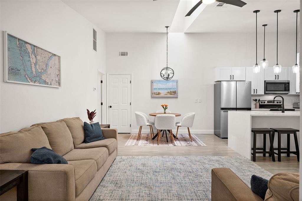 a living room with furniture kitchen view and a refrigerator