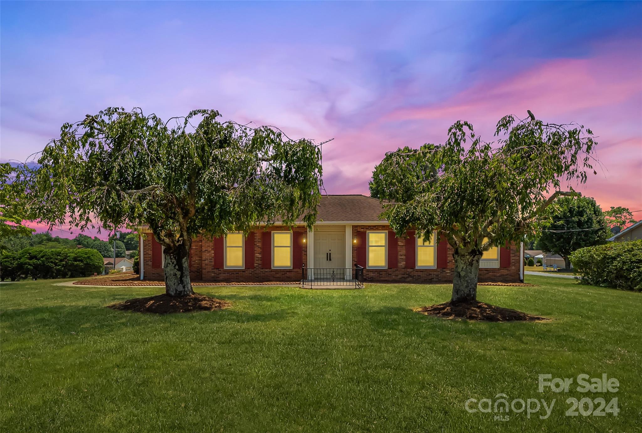 a front view of a house with a tree in a yard