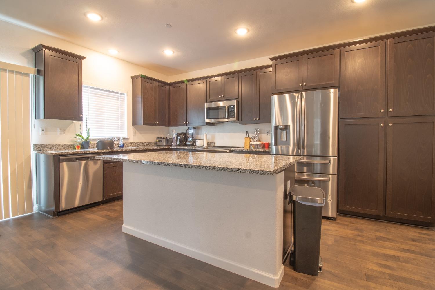 a kitchen with kitchen island a sink stainless steel appliances and cabinets