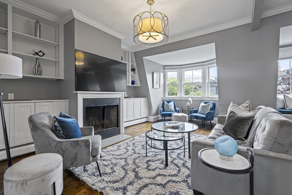 a living room with furniture a flat screen tv and a fireplace