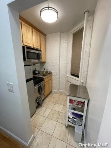 a kitchen with granite countertop a stove a sink and a microwave