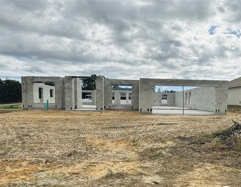 a big room with yard and front view of house