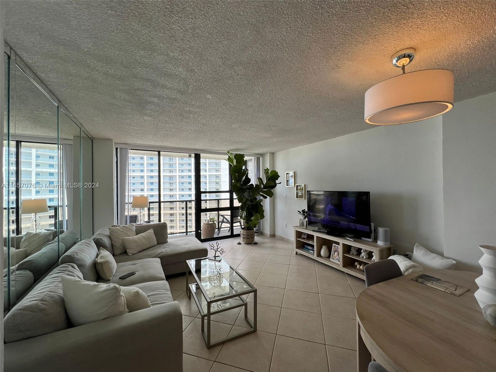 a living room with furniture a flat screen tv and a window