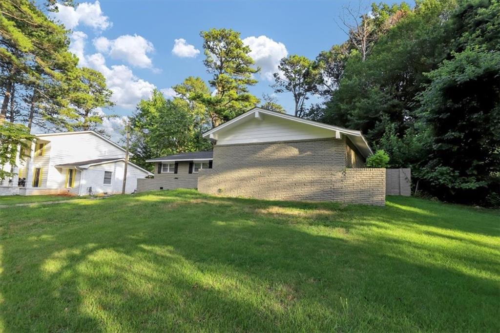 a front view of a house with a yard and trees