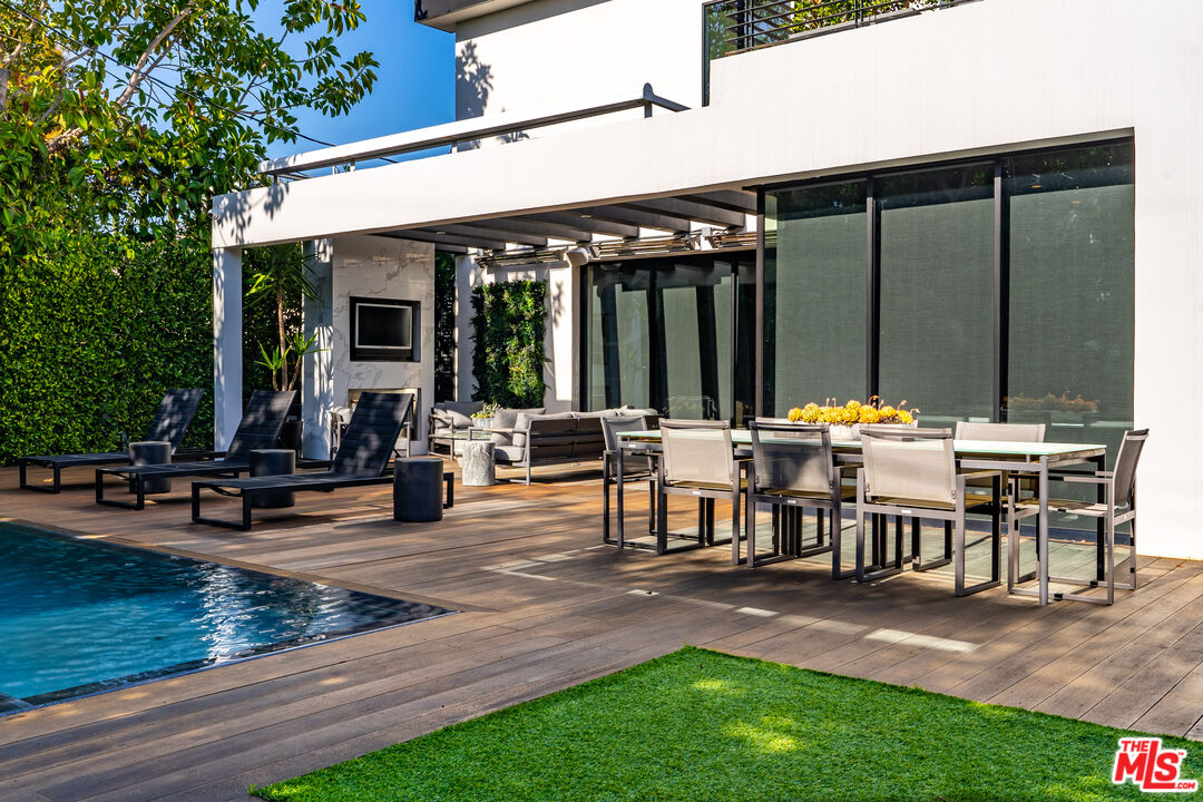 a view of a patio with table and chairs potted plants and large tree