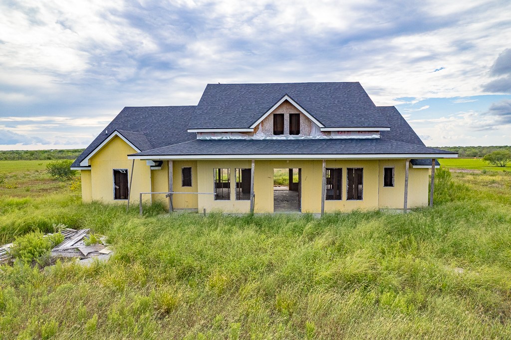 a front view of house with yard and trees around