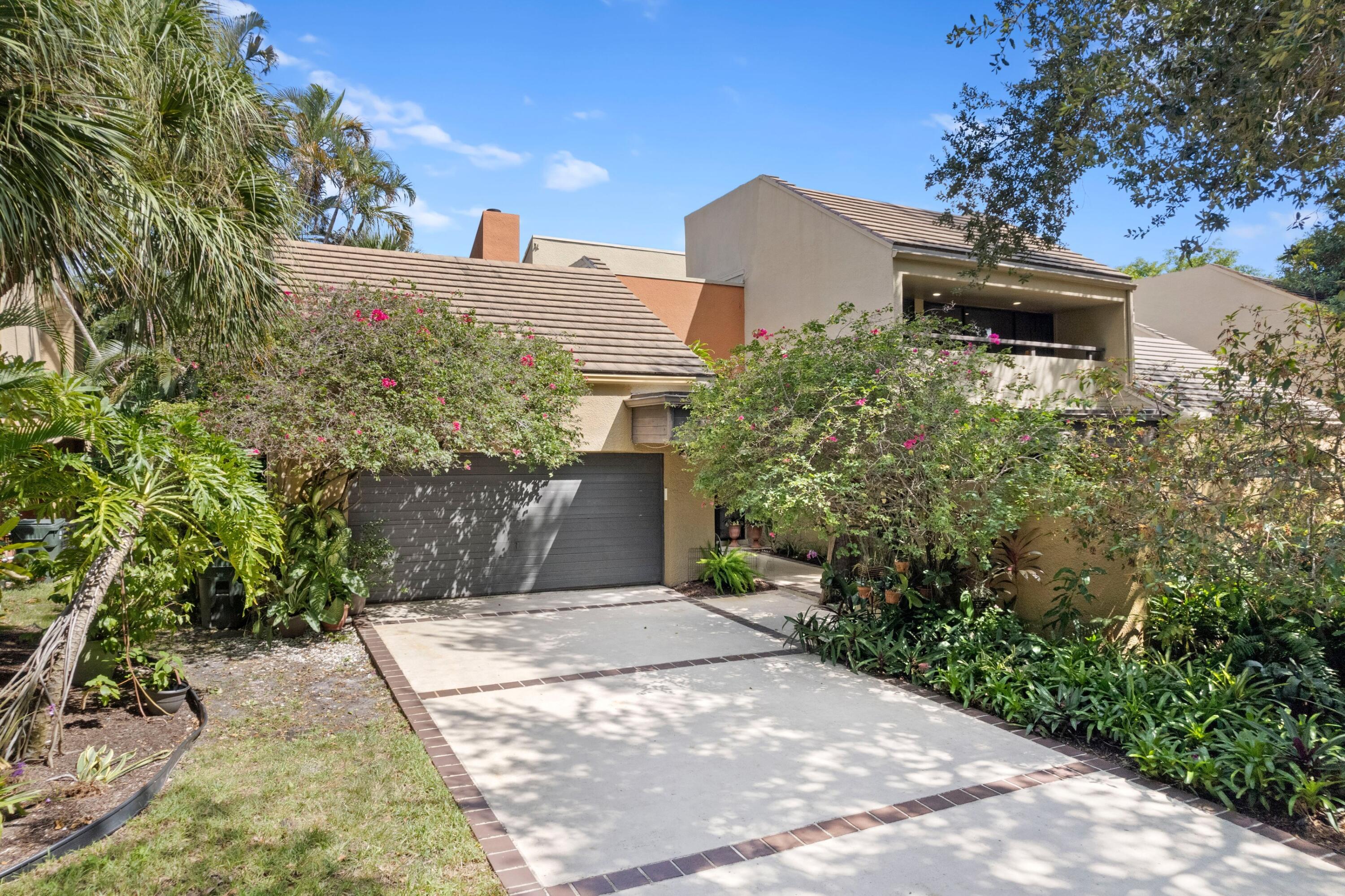 a front view of a house with a yard and trees