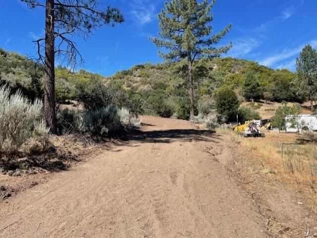 a view of dirt road with a building in the background