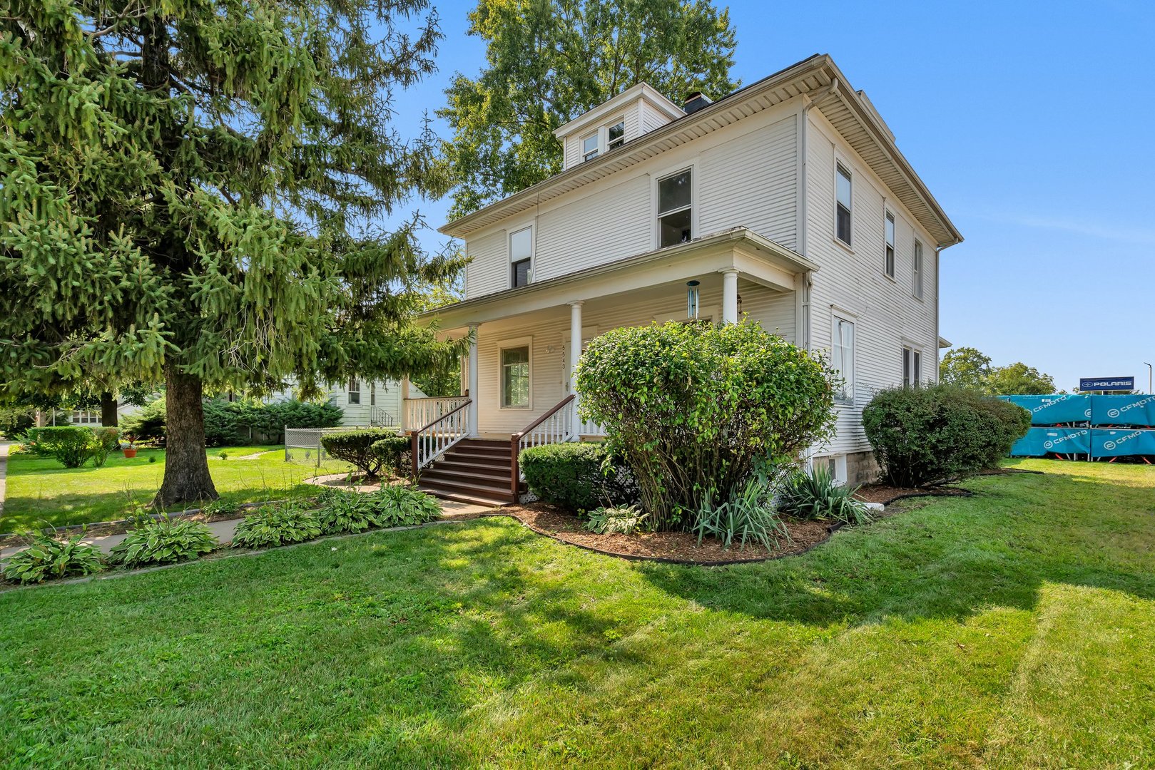 a front view of a house with a yard and trees