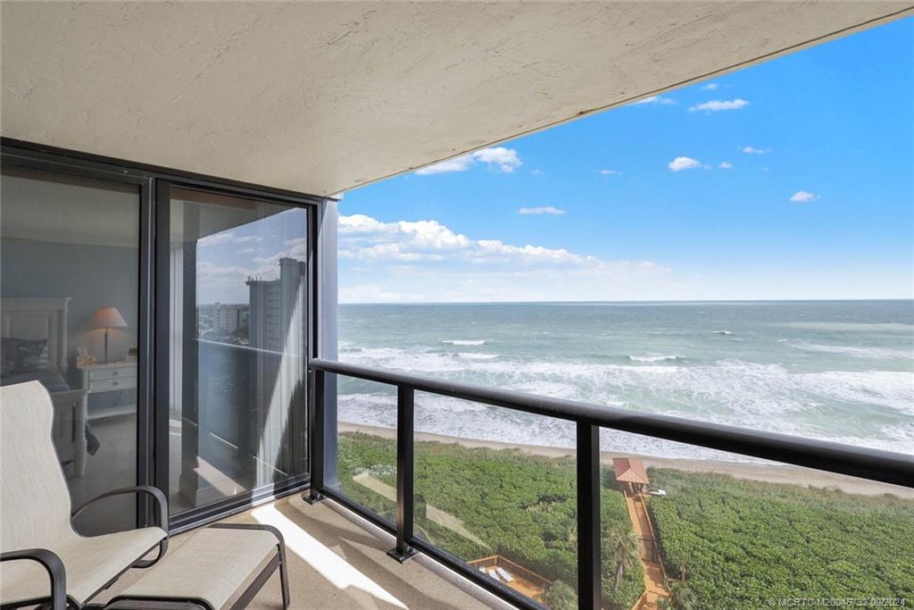 a view of a floor to ceiling window and an ocean view