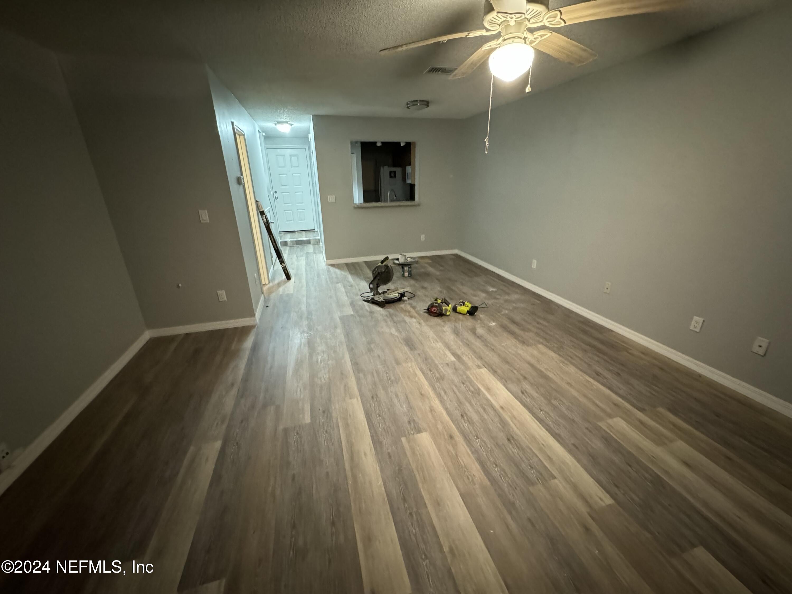 a room with wooden floor and a ceiling fan