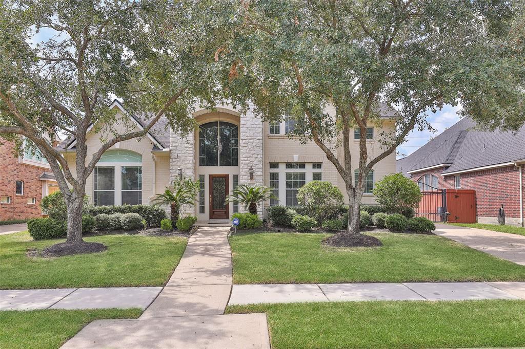 a front view of a house with a yard and plants