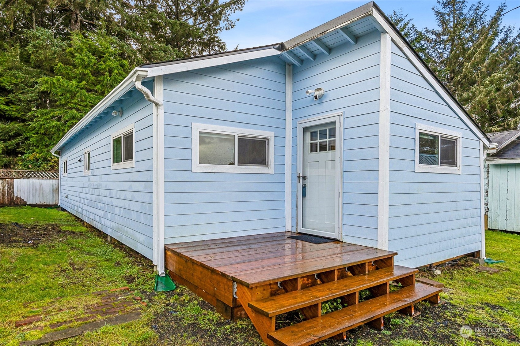 a view of a house with a small space and wooden deck