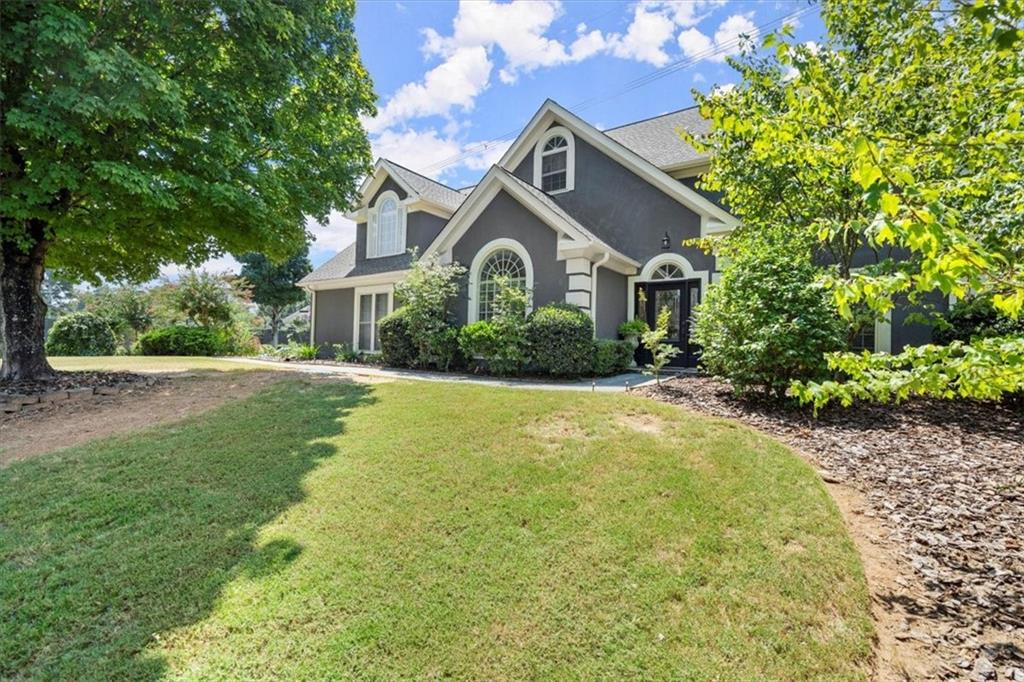 a front view of a house with yard and green space