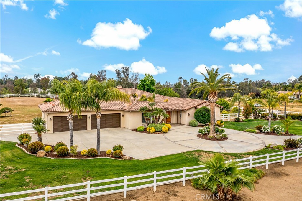 a view of a house with swimming pool lawn chairs and a yard