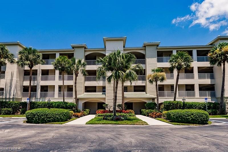 a front view of multi story residential apartment building with yard and green space