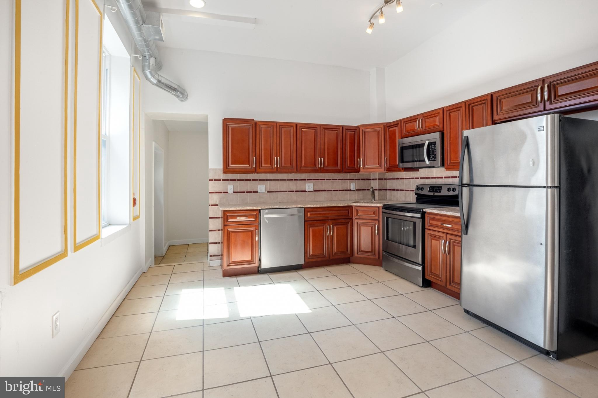 a kitchen with stainless steel appliances granite countertop a refrigerator sink and cabinets