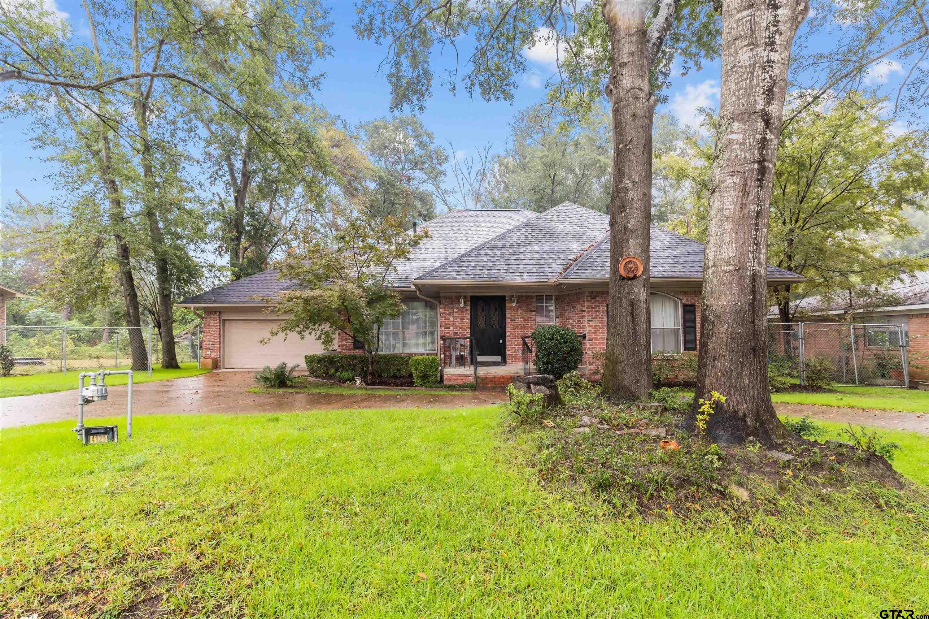 a view of a house with a yard patio and a tree