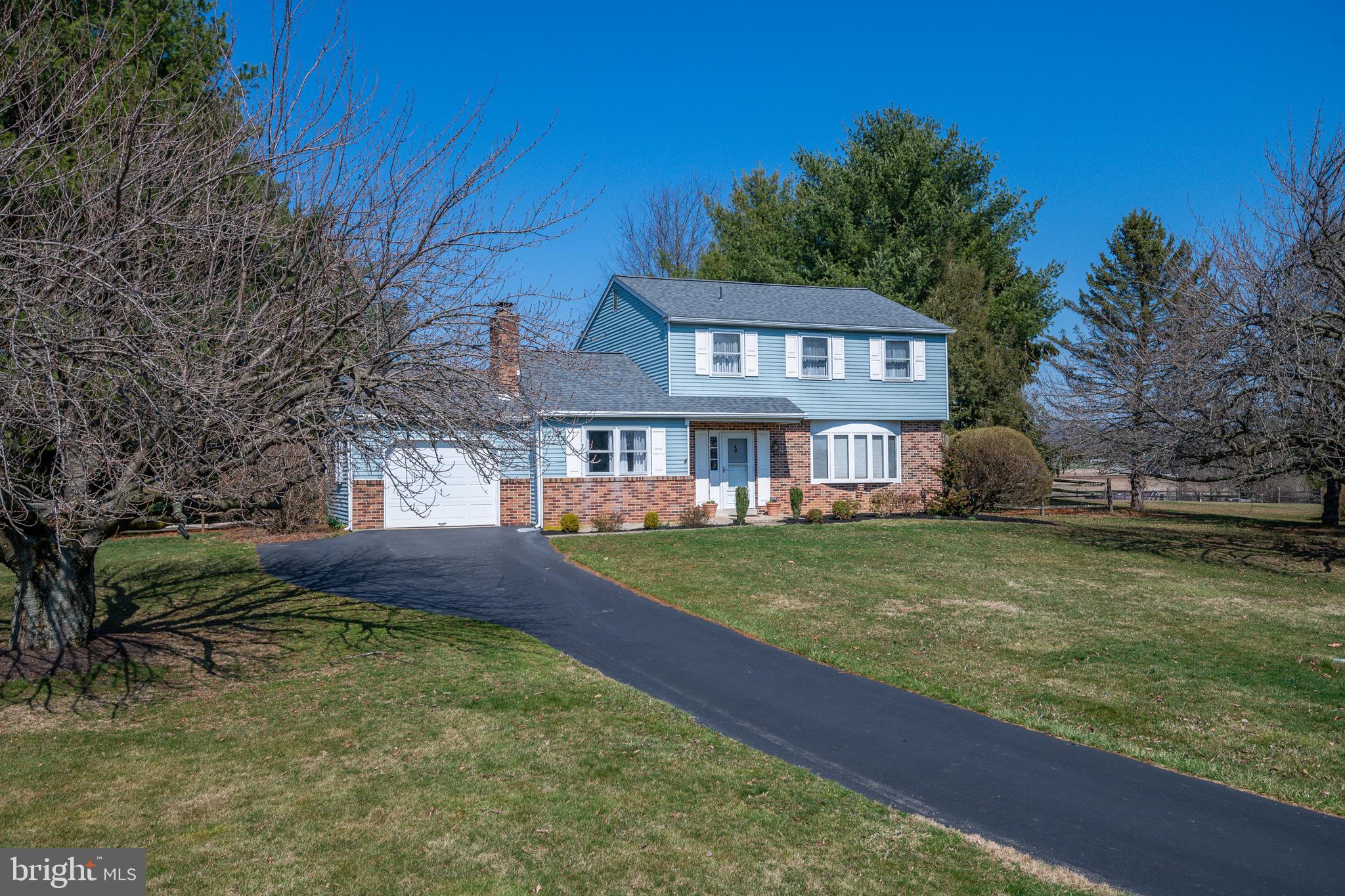 a front view of house with yard and trees