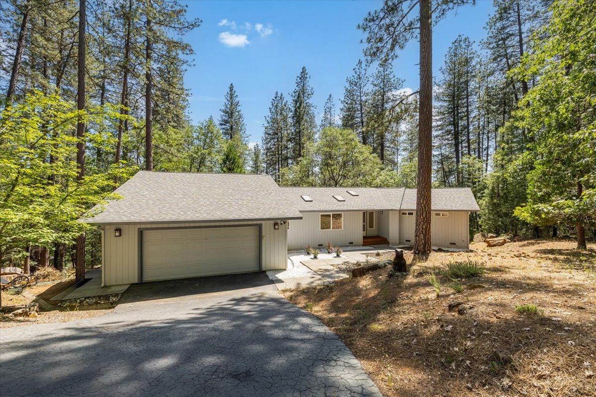 a front view of a house with a yard and trees