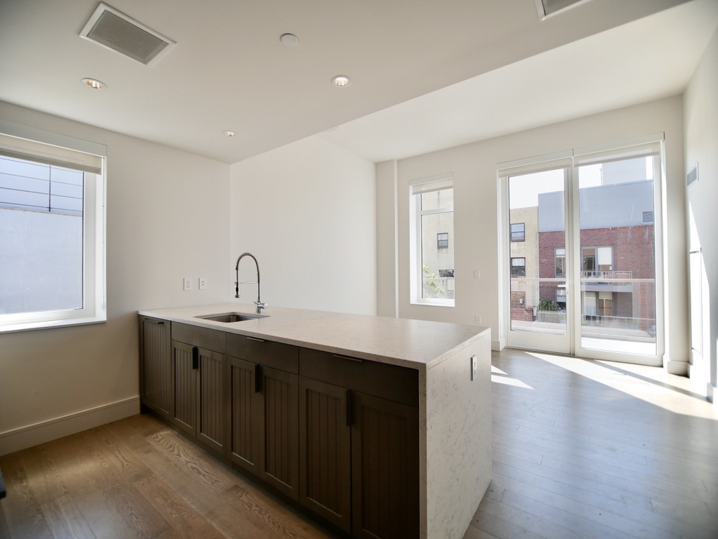 a kitchen with stainless steel appliances granite countertop a sink a stove and a wooden floors