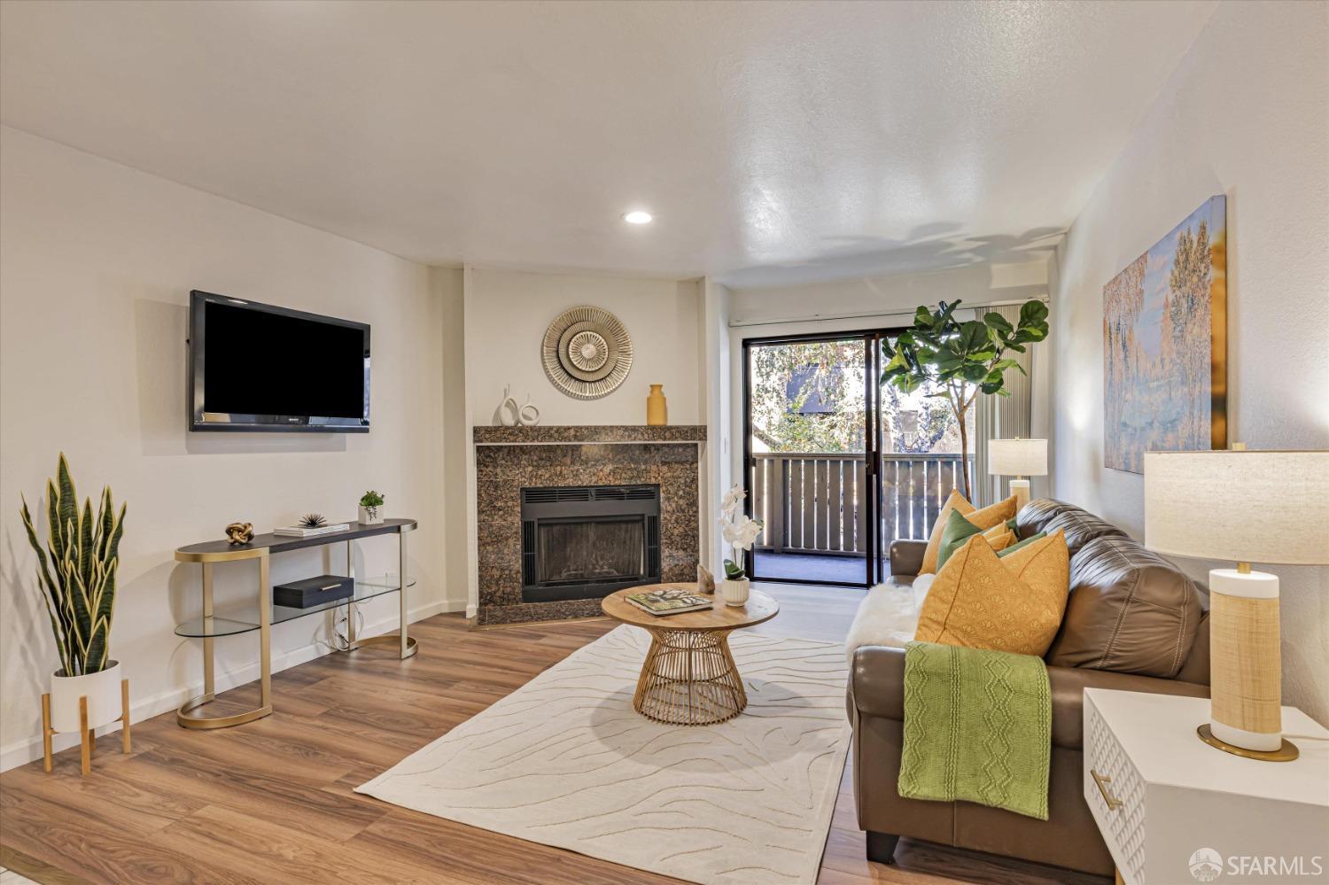 a living room with furniture a fireplace and a flat screen tv