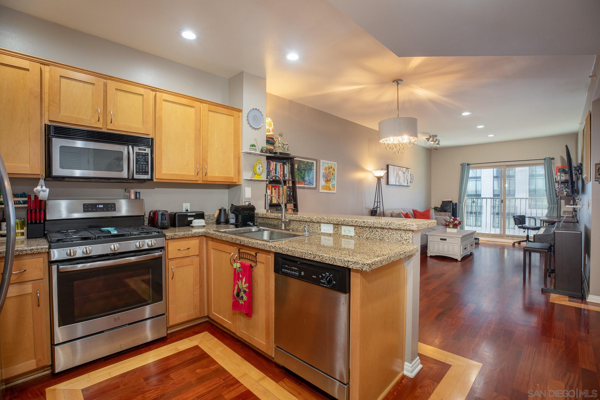 a kitchen with stainless steel appliances granite countertop a stove and a wooden floors