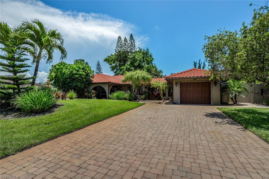 a front view of a house with a yard and a garage