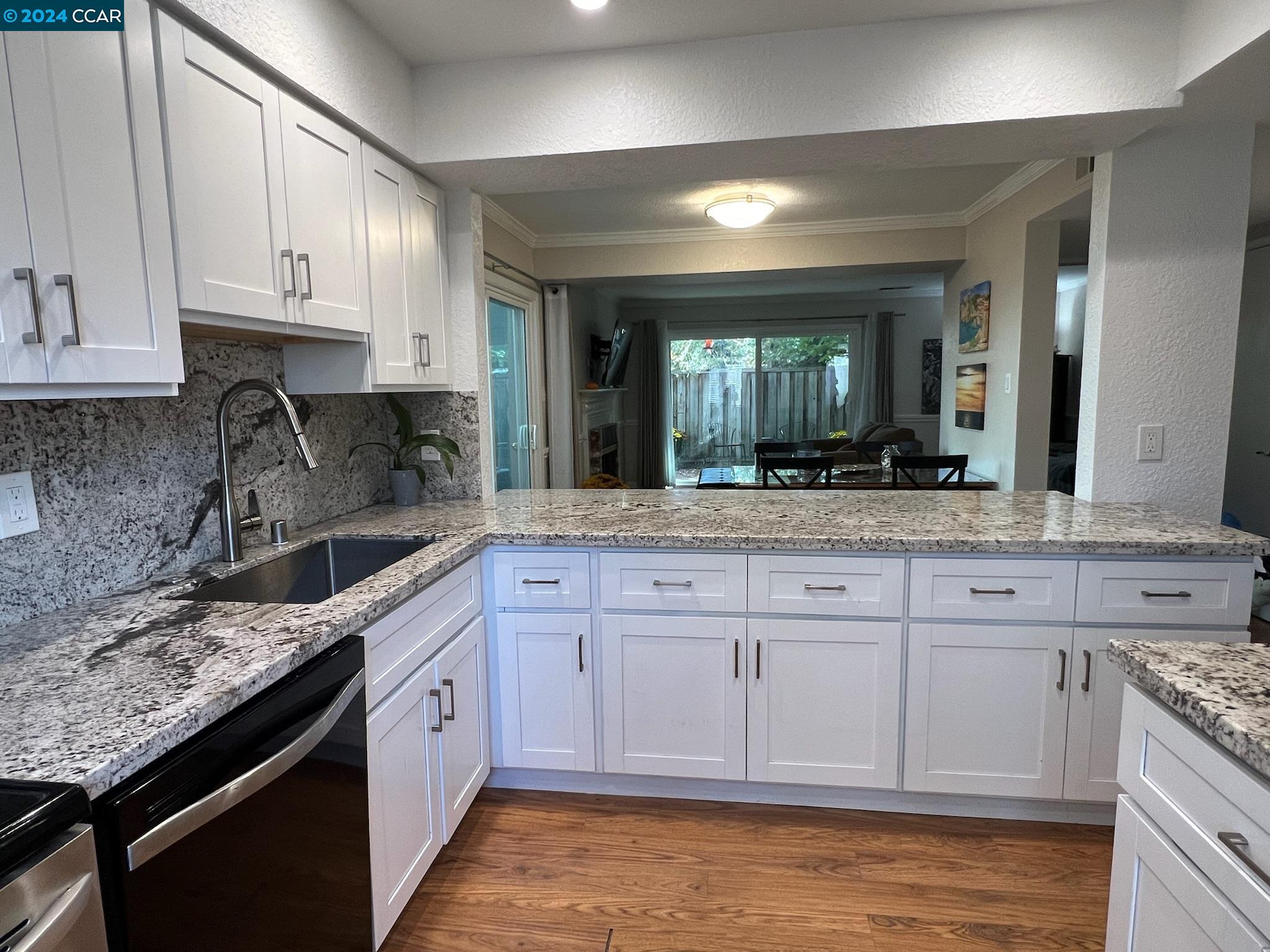 a kitchen with stainless steel appliances granite countertop a sink stove and cabinets