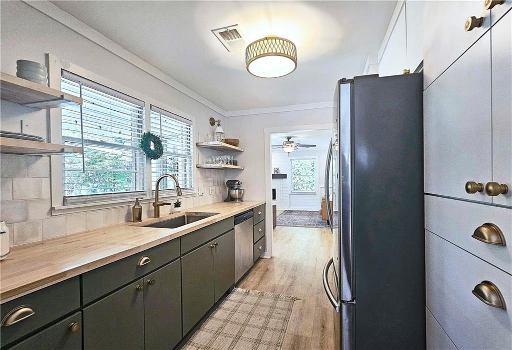 a kitchen with stainless steel appliances granite countertop a refrigerator and a sink