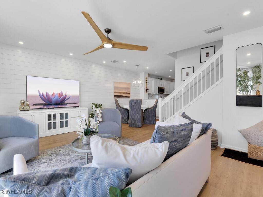 a living room with furniture kitchen view and a chandelier