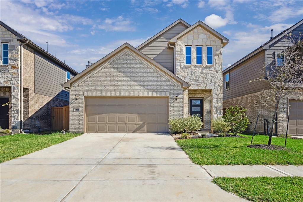 a front view of a house with a yard and garage