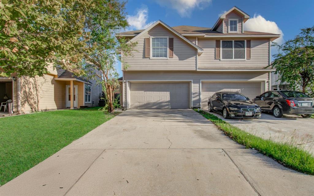 Charming two-story townhouse, boasting a spacious two-car garage and a beautifully manicured lawn, nestled in a serene neighborhood. 