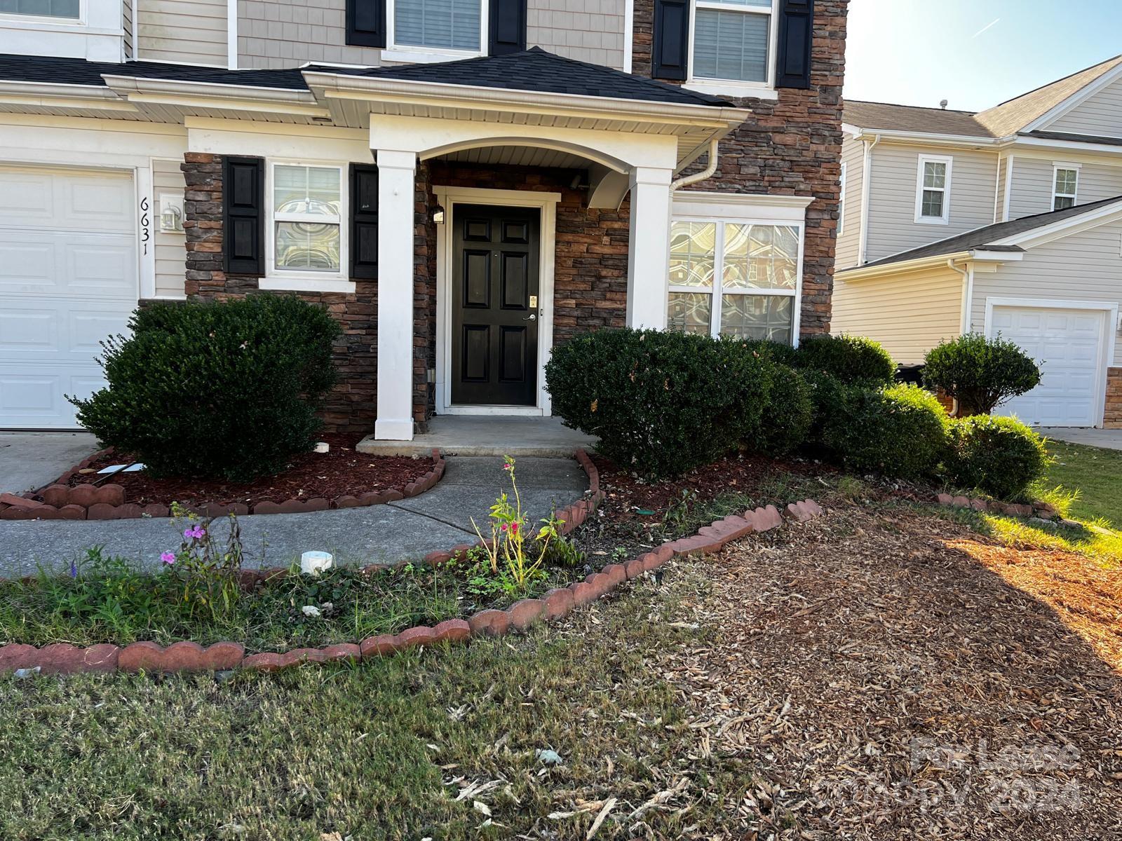 a view of a house with brick walls and flower plants