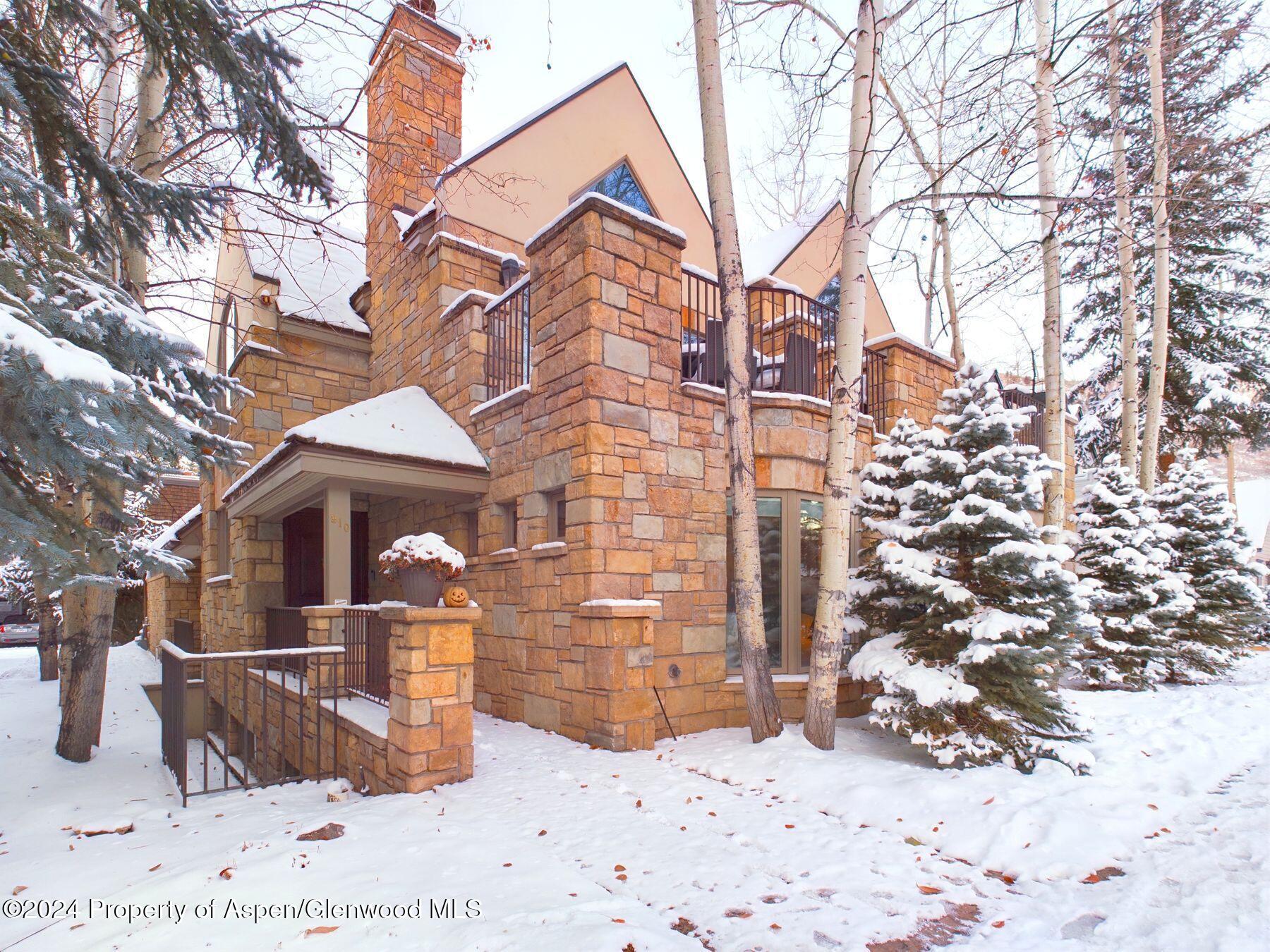 a front view of a house with a yard covered in snow