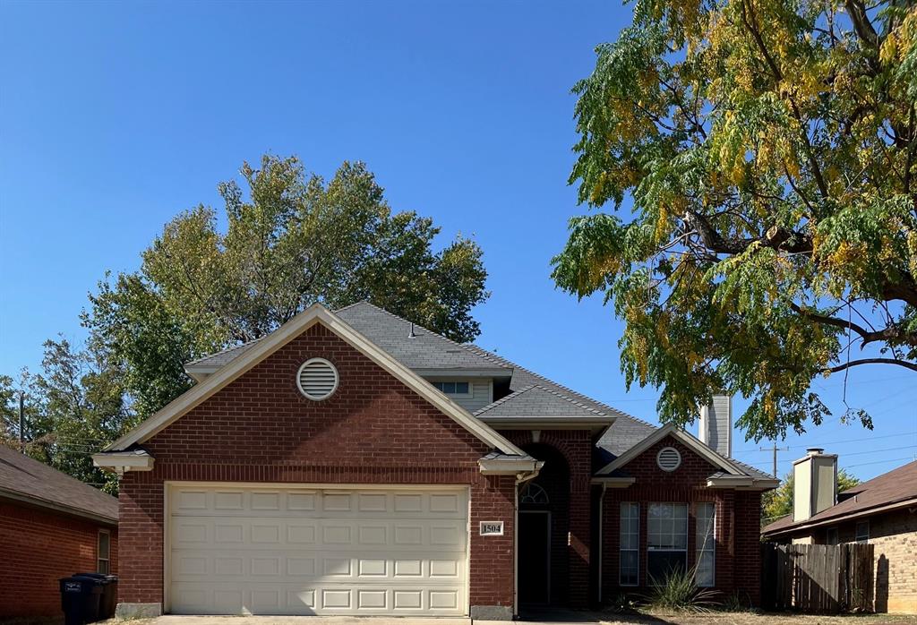 a front view of a house with a tree