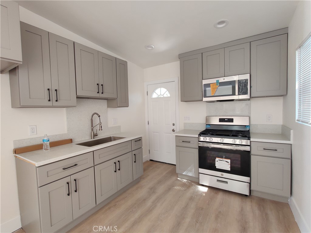 a kitchen with stainless steel appliances granite countertop a stove a sink and a microwave