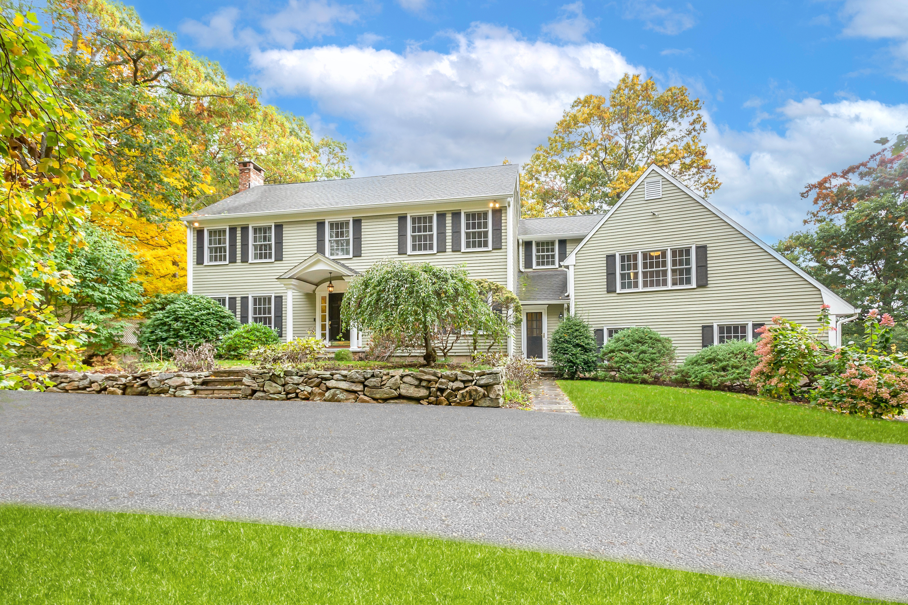 a front view of a house with a garden and trees