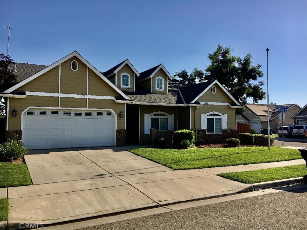 a front view of a house with yard and parking