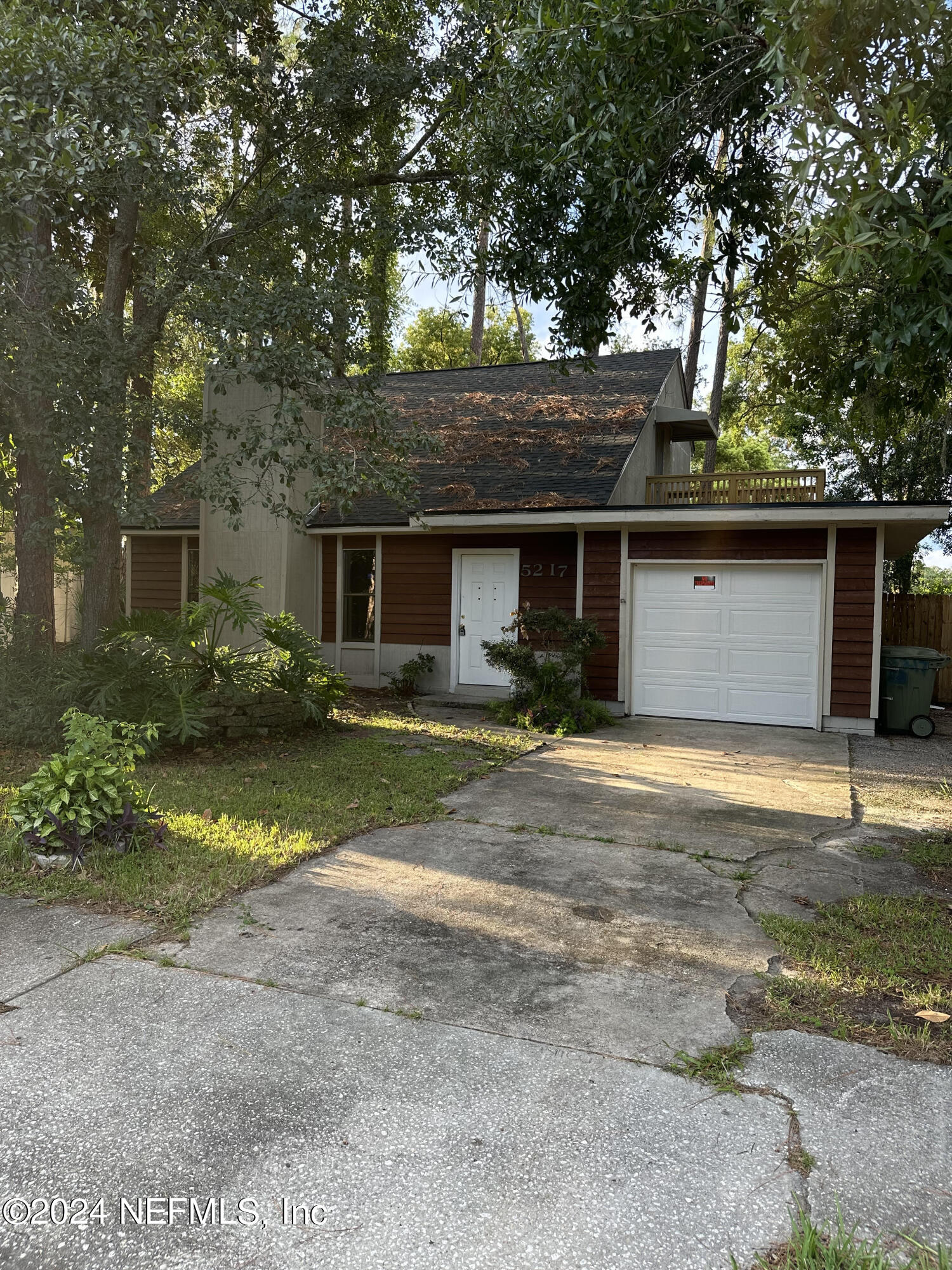 a front view of house with yard and trees around