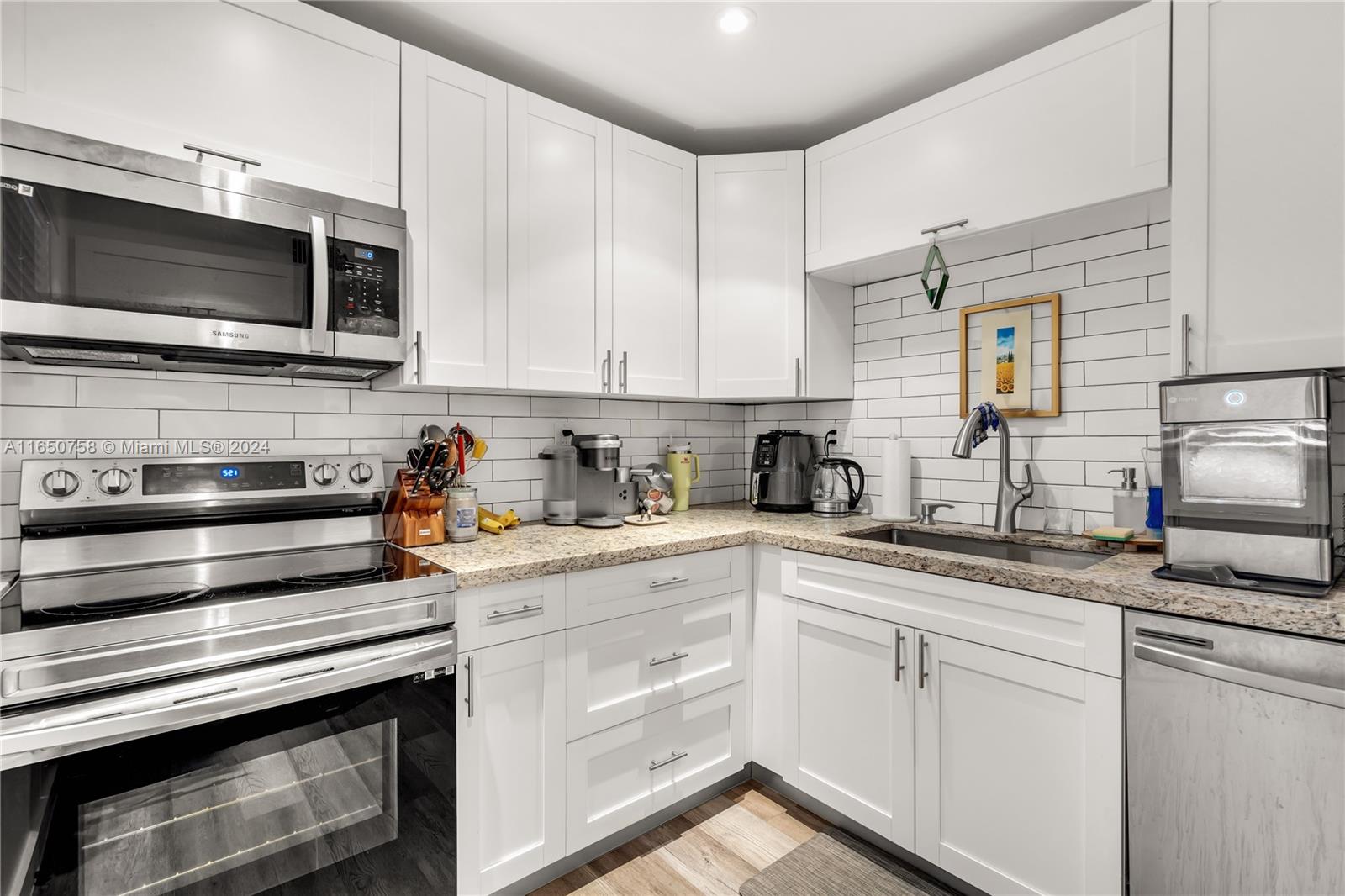 a kitchen with stainless steel appliances granite countertop a sink stove and microwave