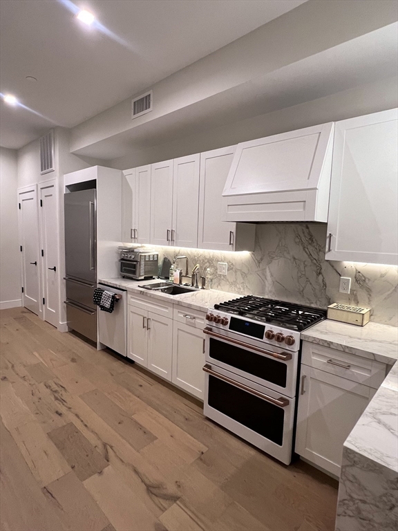 a kitchen with stainless steel appliances a stove a sink and a refrigerator