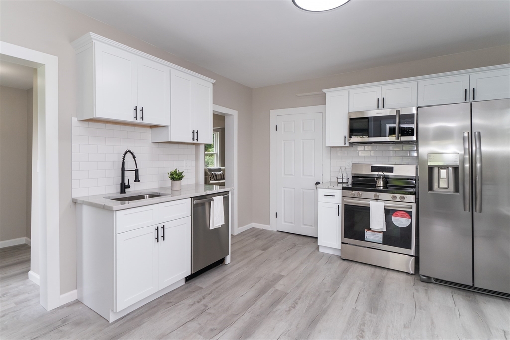 a kitchen with stainless steel appliances a sink stove and refrigerator