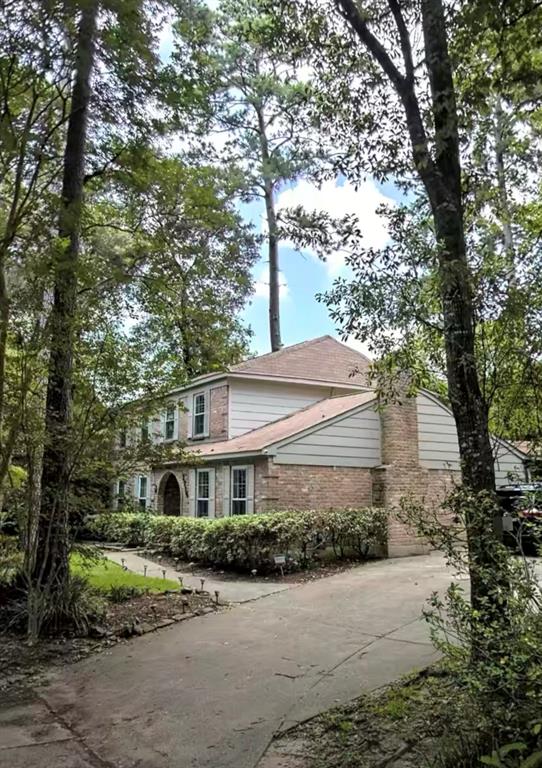 a front view of a house with a yard and tree s