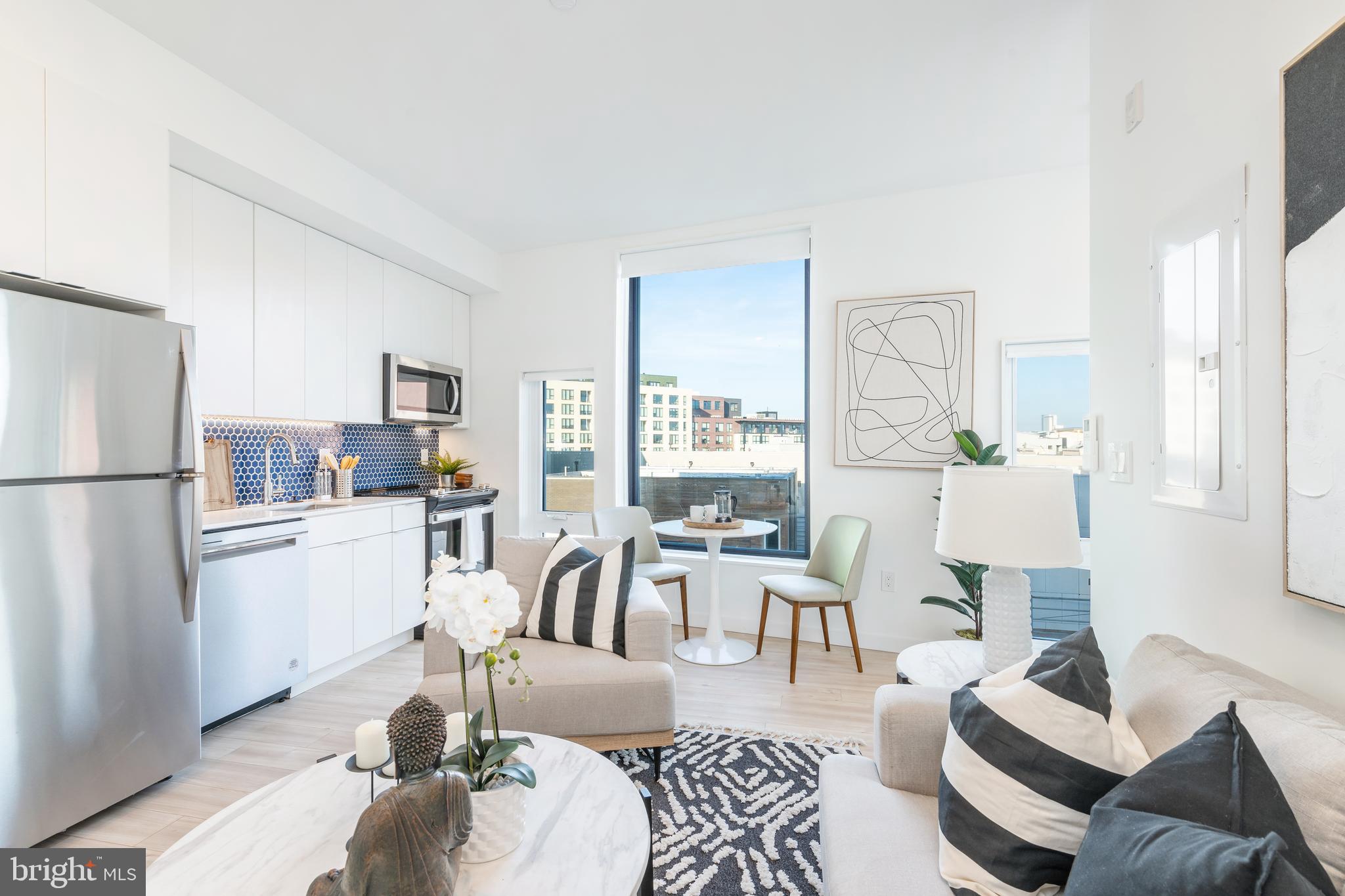 a living room with furniture and a kitchen view